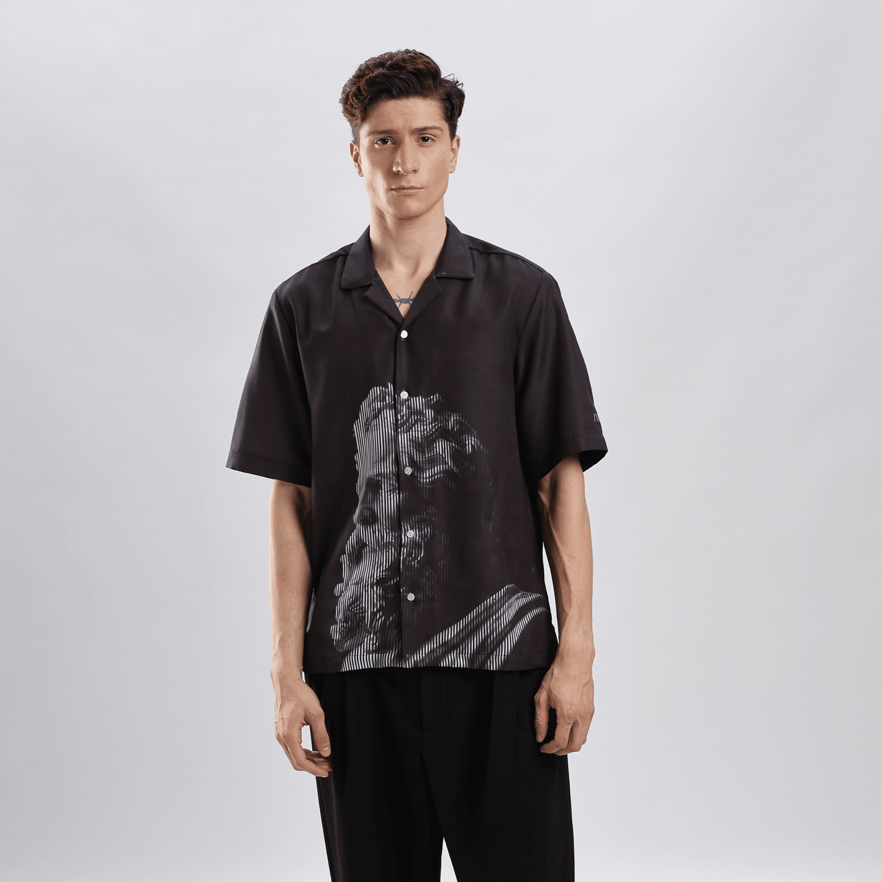 Stylera black short sleeve button shirt with classical statue graphic worn by model casual statement shirts for men