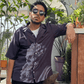 Stylera black short sleeve printed shirt worn by man leaning on terrace with plants casual statement shirts for men