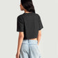 Back view of woman wearing charcoal black oversized crop top paired with light blue denim jeans