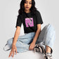 Stylera charcoal black oversized crop top worn by woman with graphic print paired with light blue jeans and sneakers