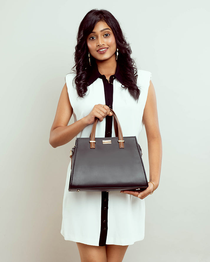 Charcoal caramel handbag by Stylera held by a woman in a stylish outfit