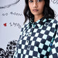 Stylera model wearing a blue and black chess board print oversized shirt with button front collar