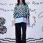 Stylera chess board print oversized shirt on model with layered blue hem and wide black trousers