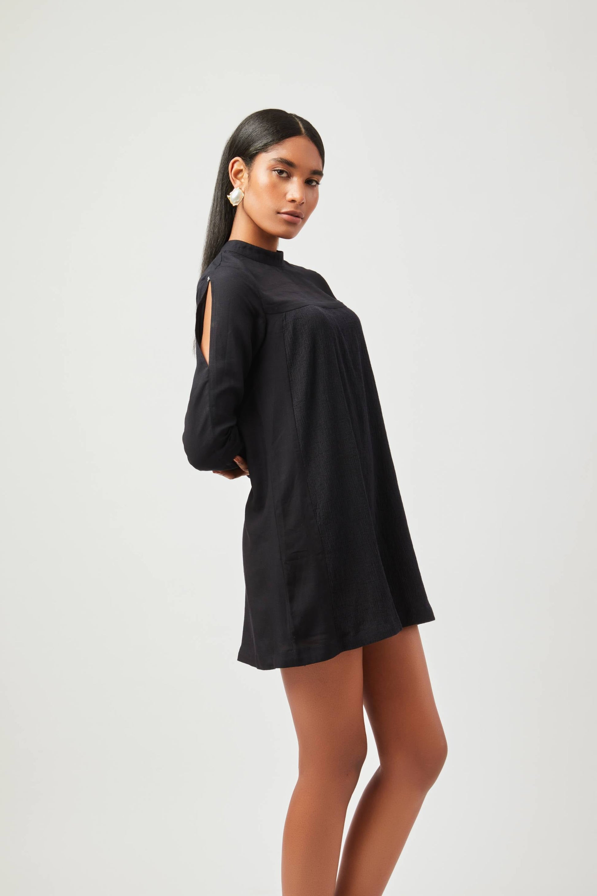 Stylera chic little black dress with long sleeves and high neckline on model