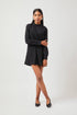 Stylera chic little black dress with long sleeves and high neckline worn by model