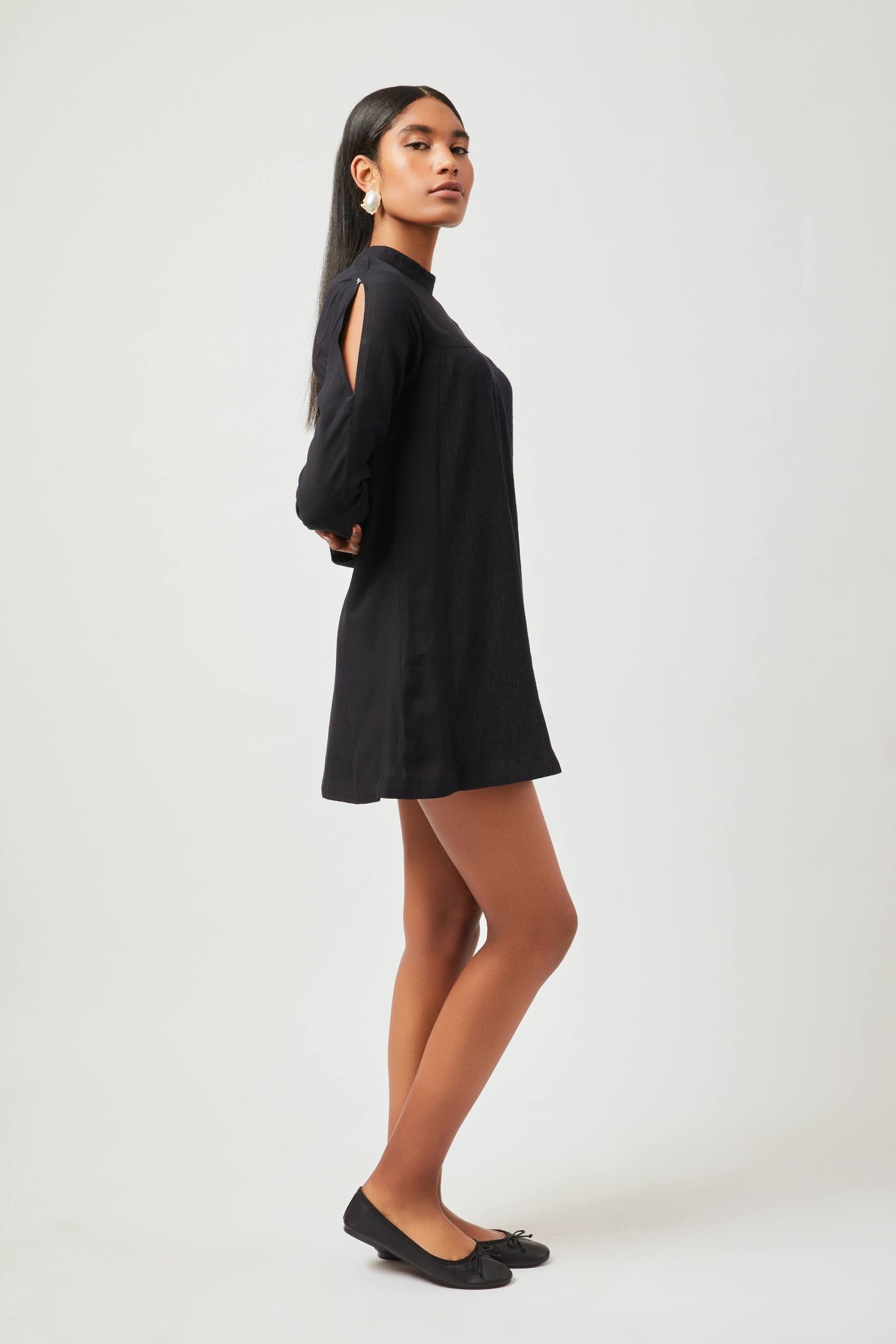 Stylera chic little black dress with long sleeves and cutout details worn with black flats