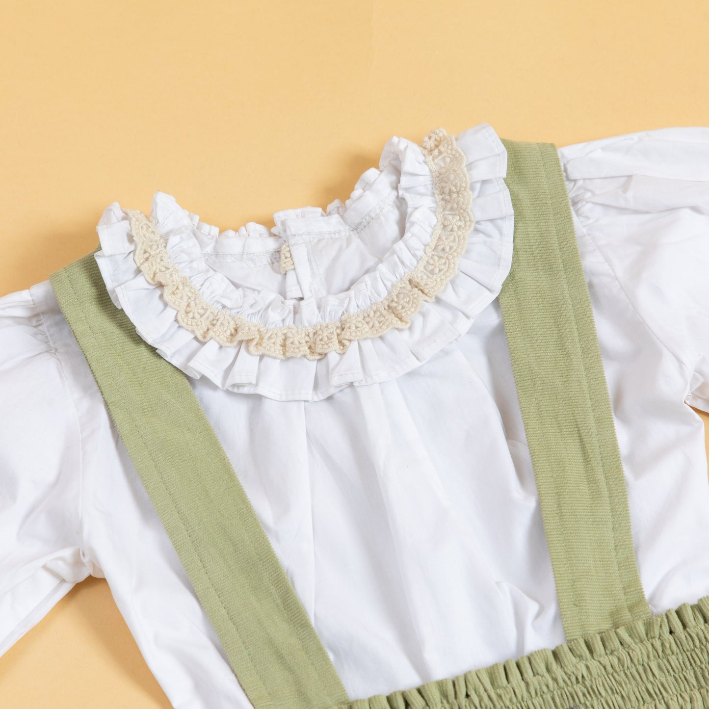 Stylera children's pinafore dress with suspenders featuring a ruffled collar and soft fabric