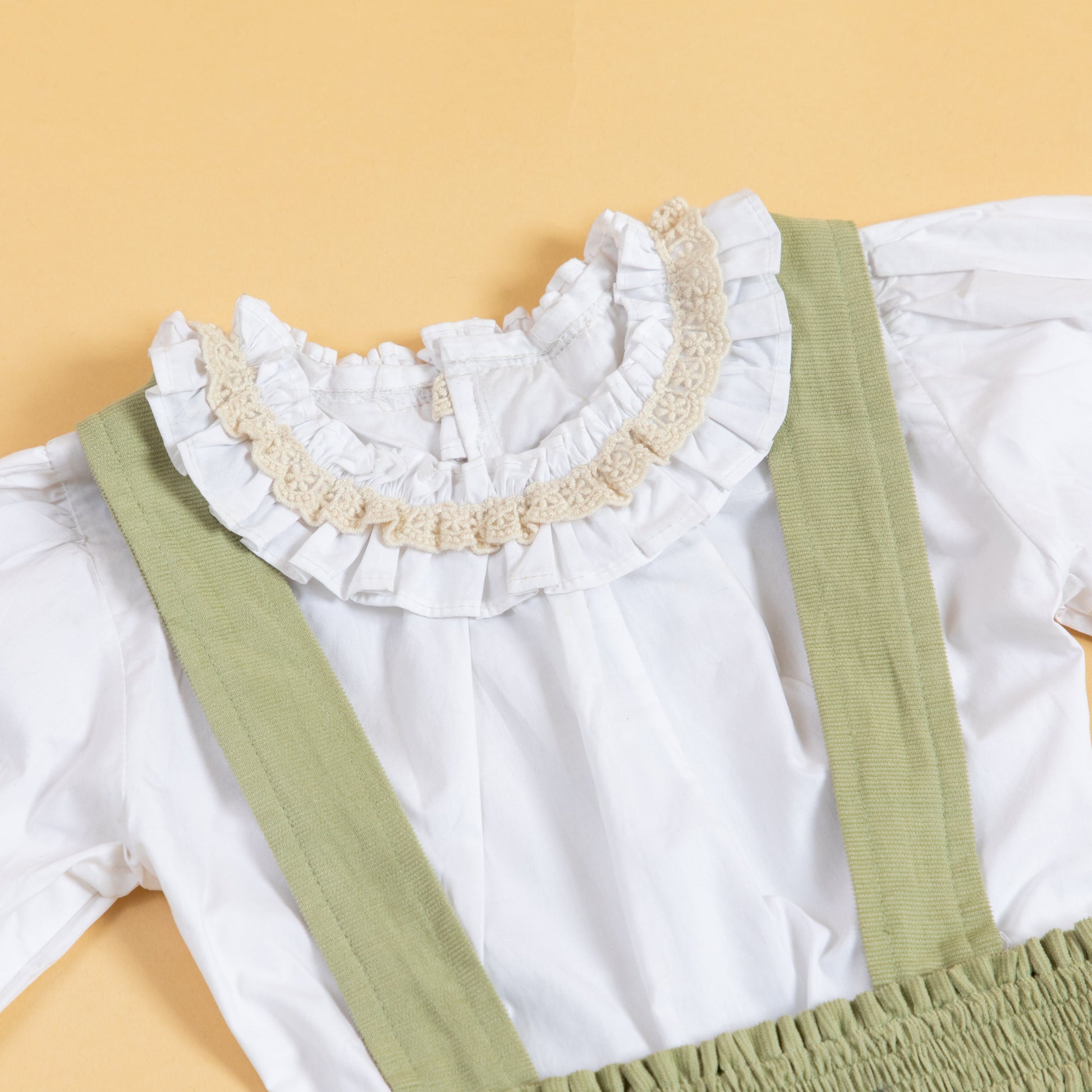 Stylera children's pinafore dress with suspenders featuring a ruffled collar and soft fabric