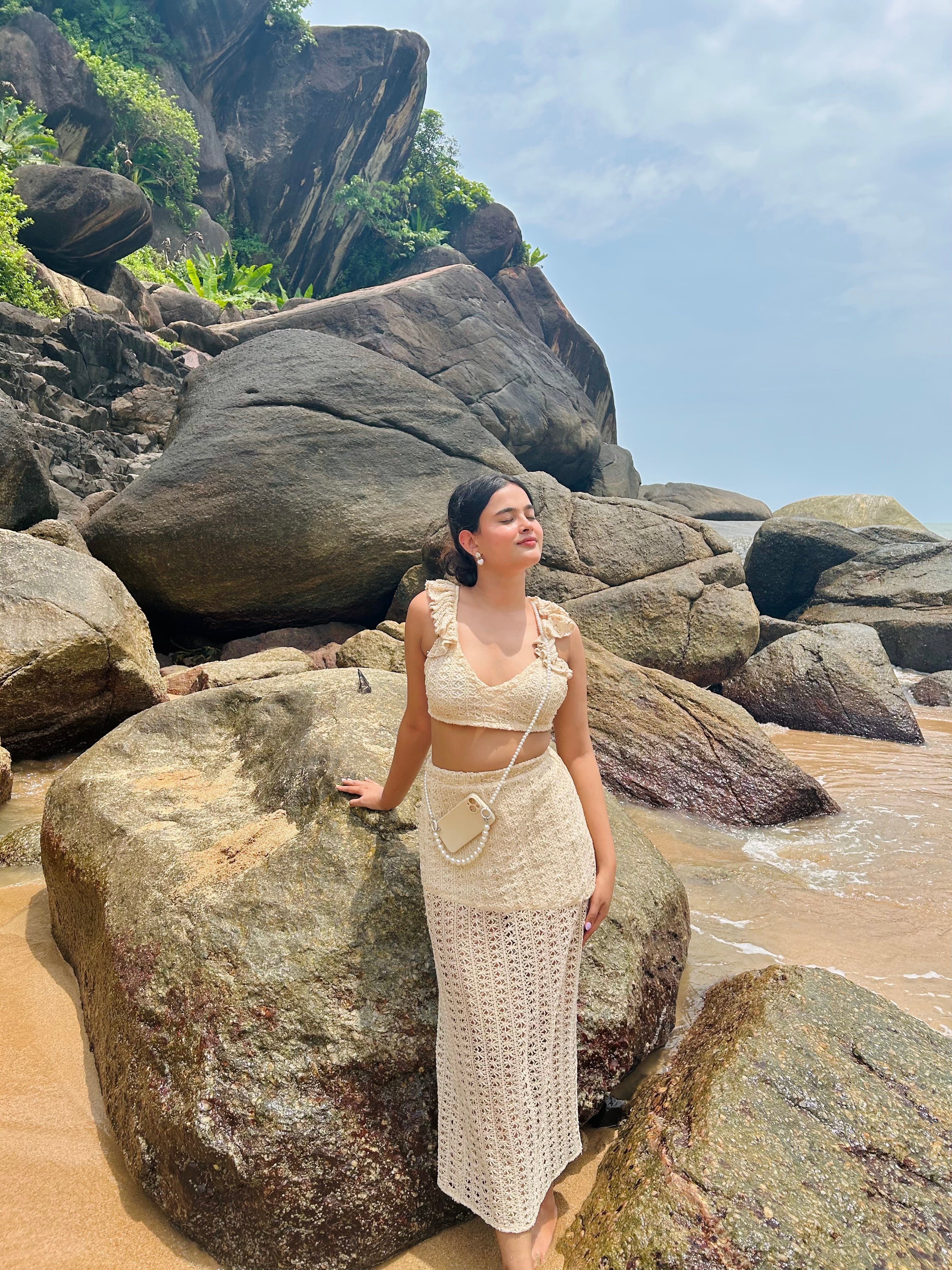 Stylera crochet two piece set with bag on model by rocky beach trendy seaside vacation outfit