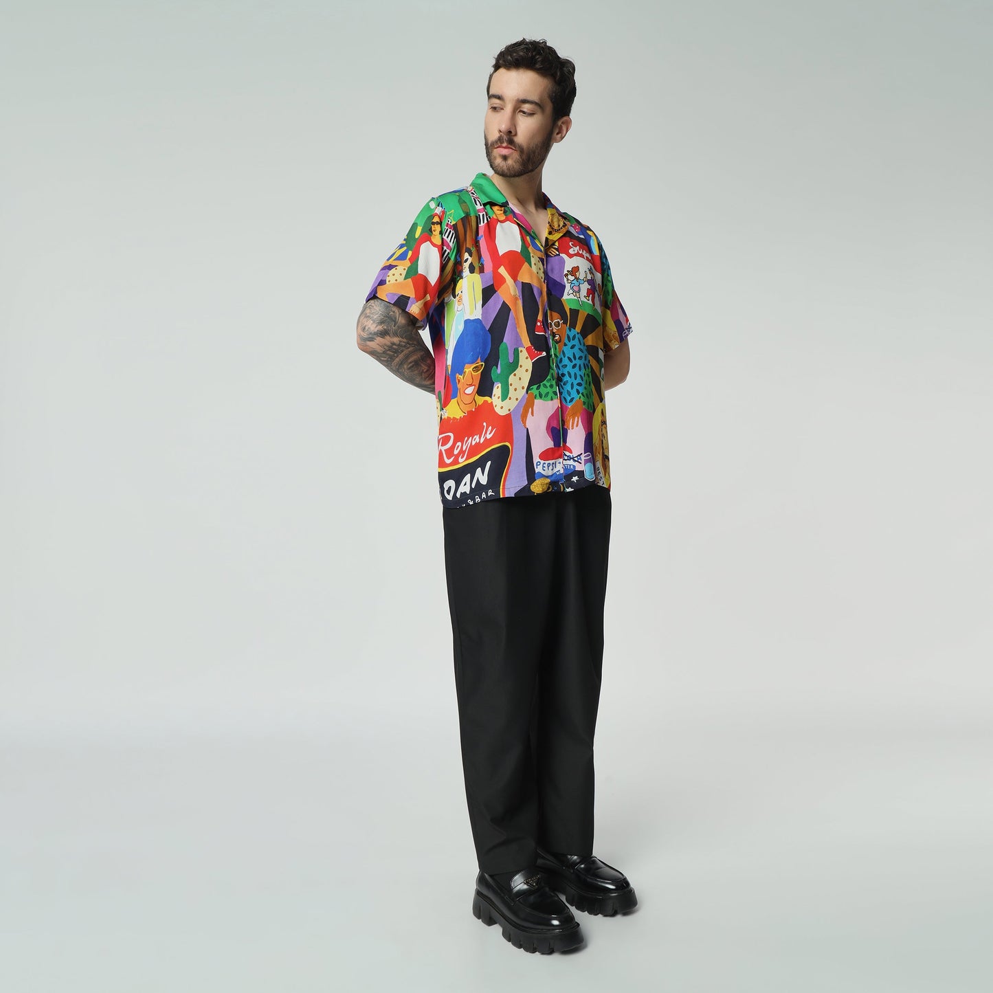 Stylera colorful summer button up shirt with vibrant patterns worn by a model in stylish black trousers