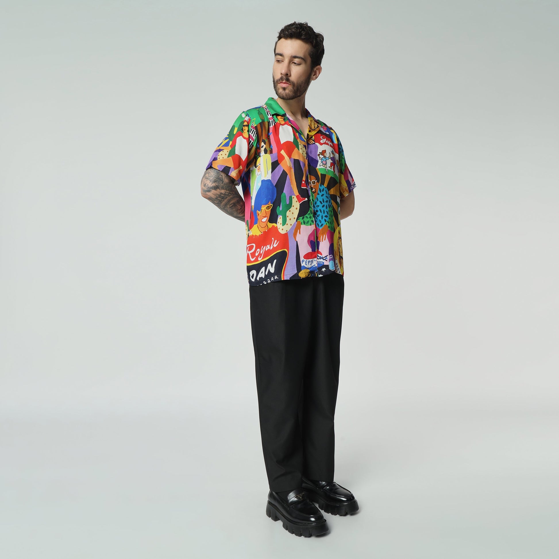 Stylera colorful summer button up shirt with vibrant patterns worn by a model in stylish black trousers