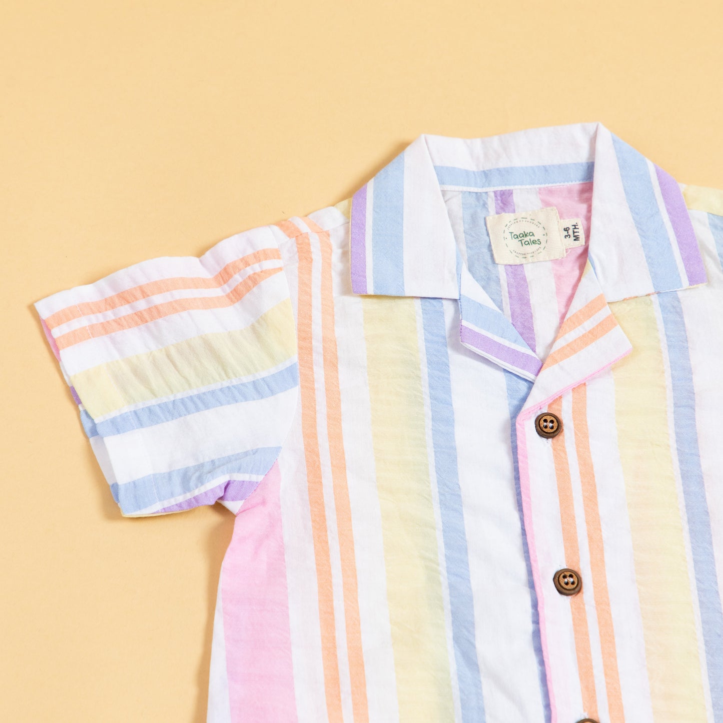 Colorful summer playsuit with striped design and wooden buttons for kids' playful outings