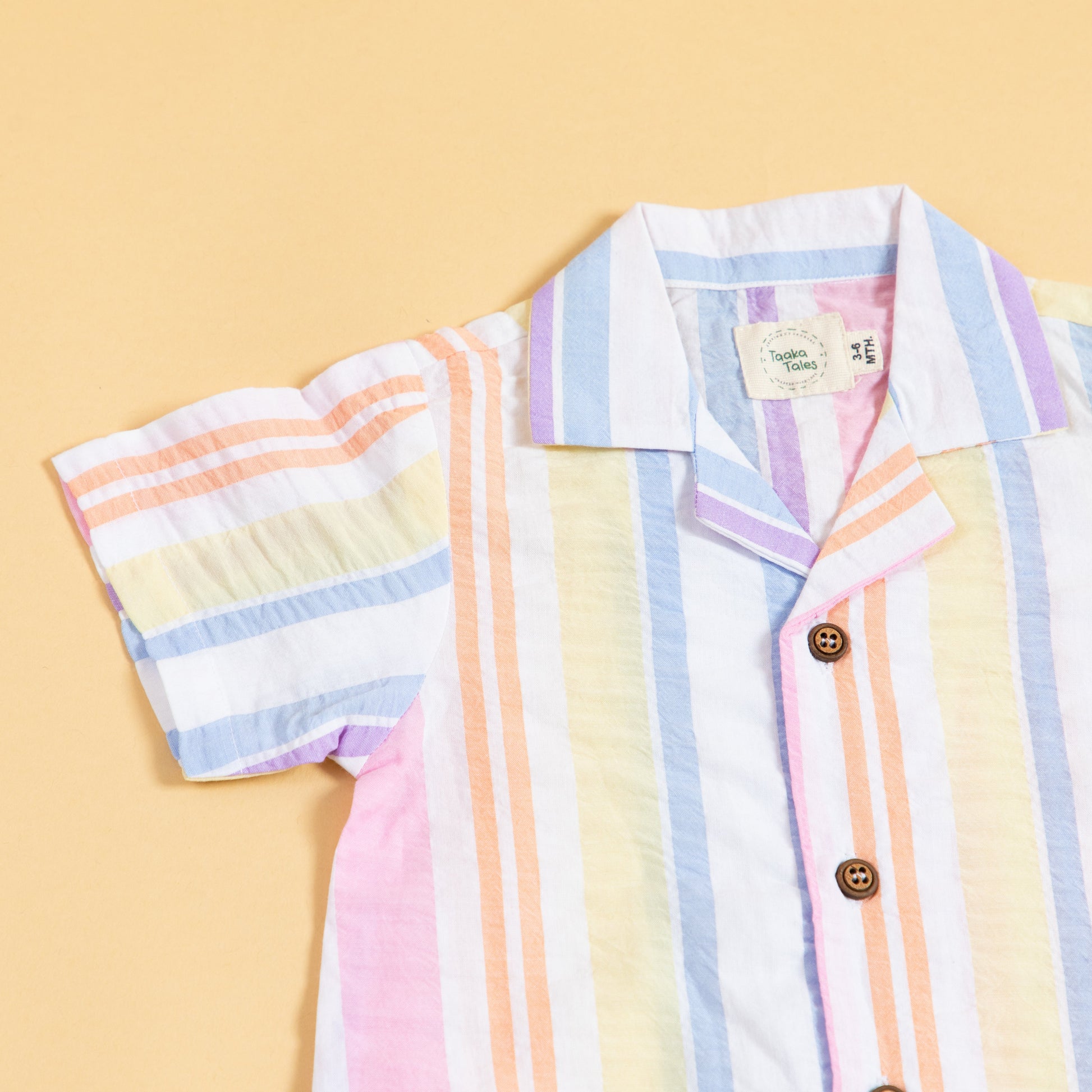 Colorful summer playsuit with striped design and wooden buttons for kids' playful outings