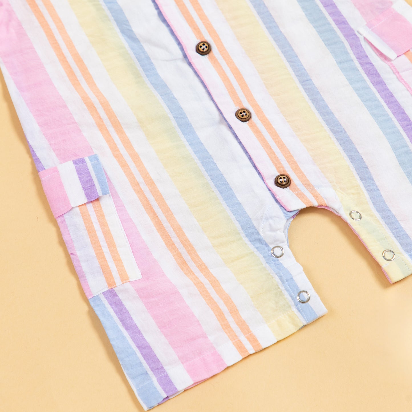 Colorful summer playsuit with striped design and button closures for playful outdoor fun