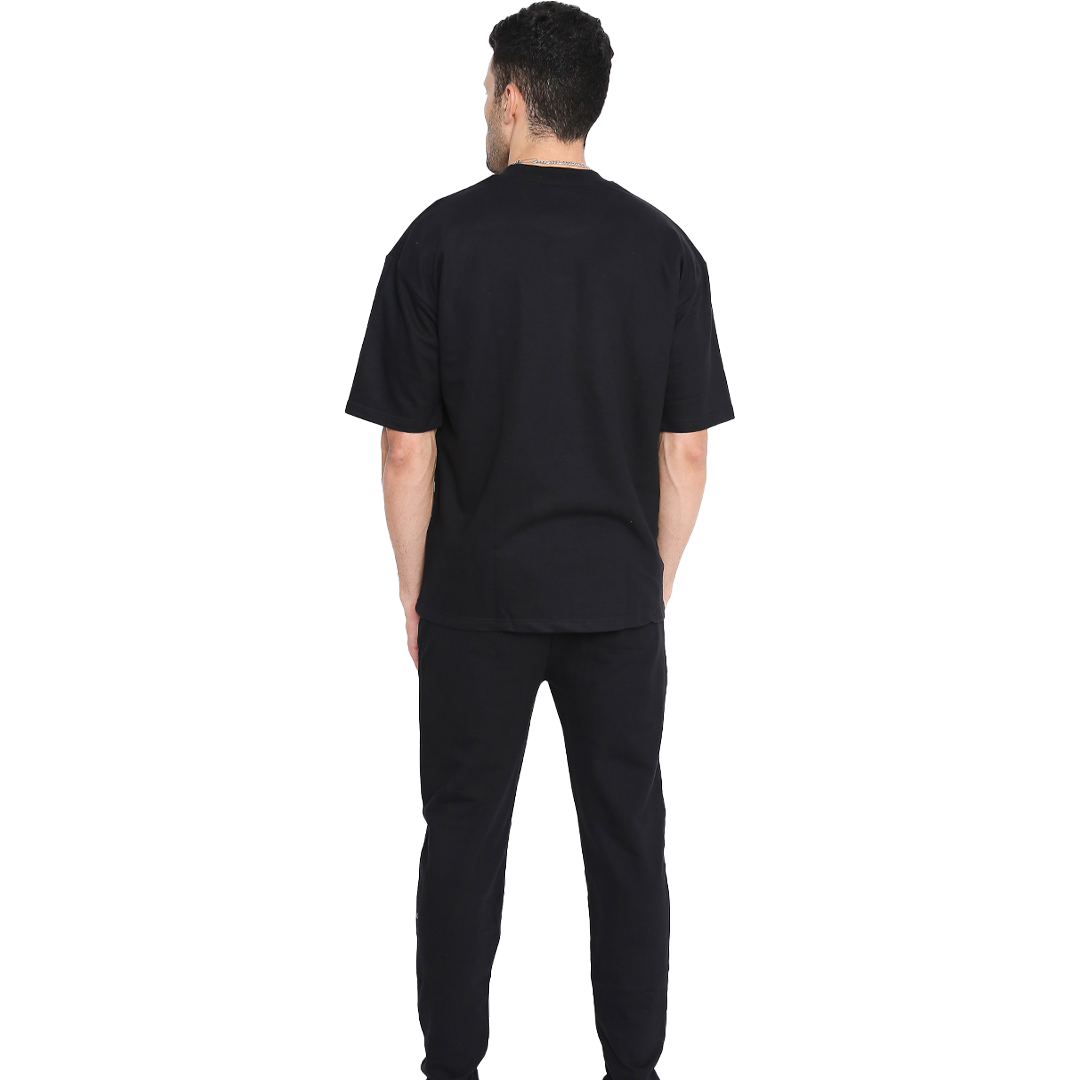 Stylera First black sweatpants rear view on model wearing matching black tee showcasing comfortable everyday sweatpants
