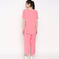 Back view of a woman wearing a comfortable summer co-ord set in bright pink, featuring a loose t-shirt and flowy pants