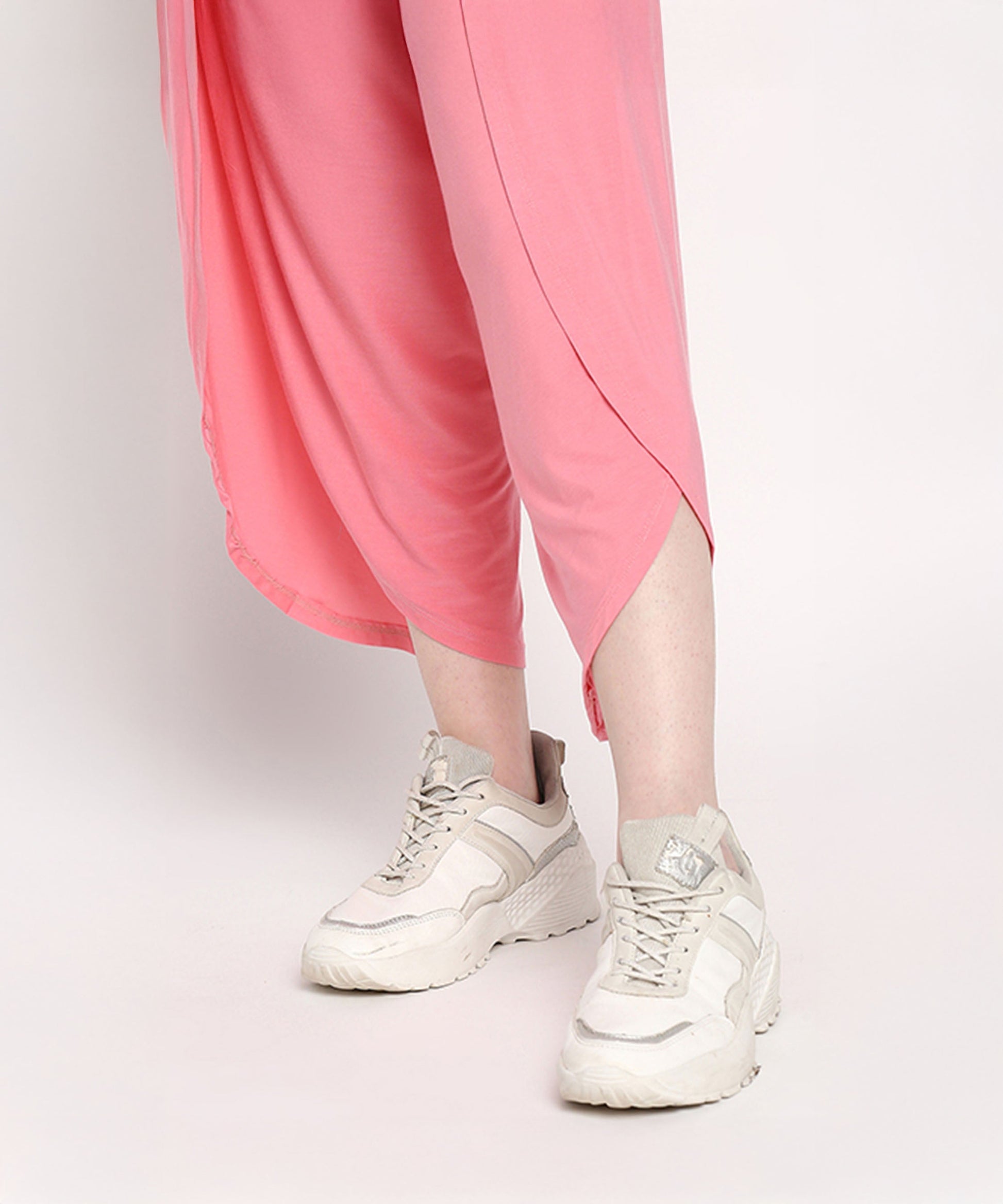 Woman wearing a comfortable summer co-ord set with pink pants and stylish white sneakers