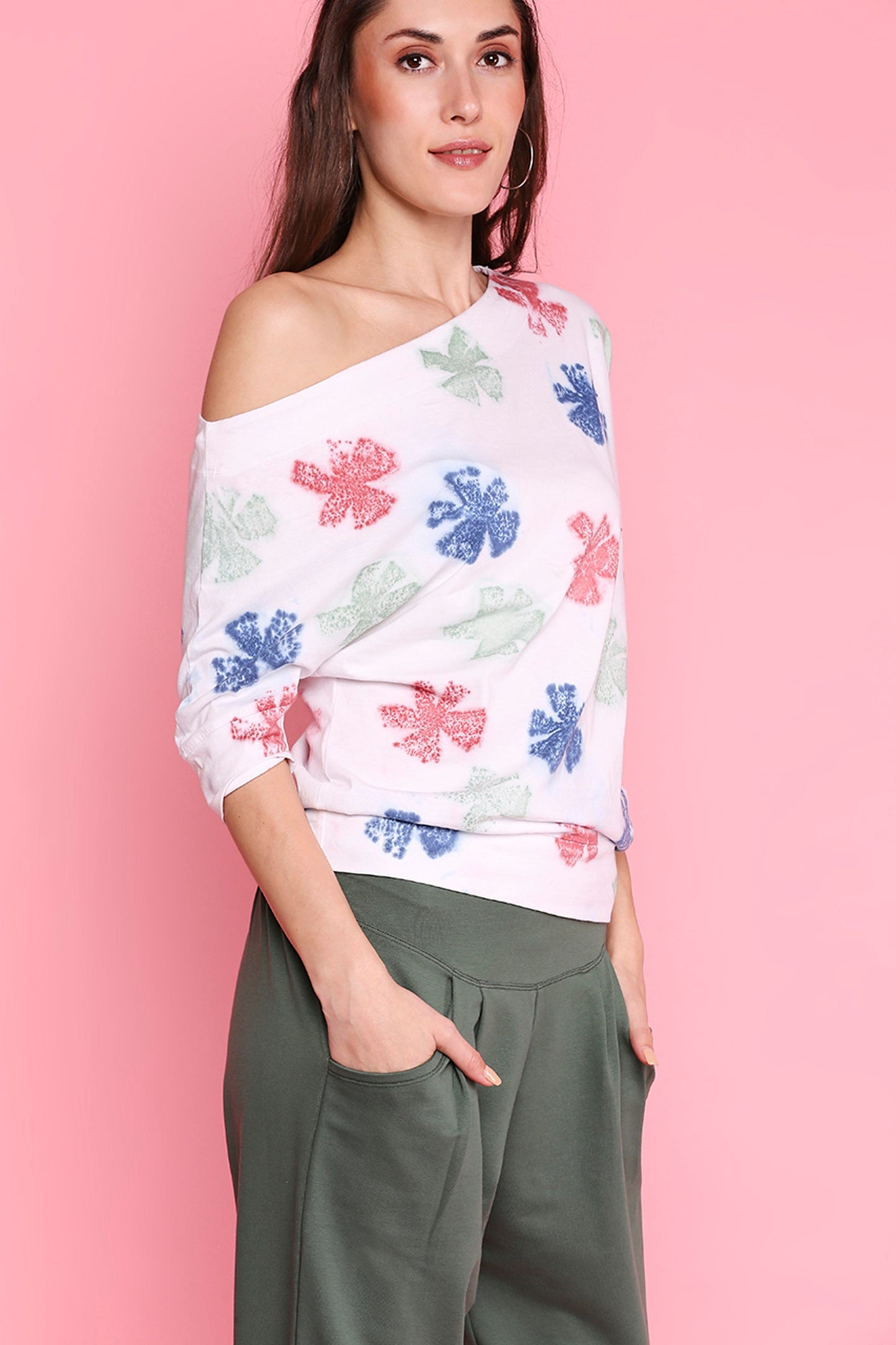 Woman wearing comfortable yoga pants with pockets and a colorful floral off-shoulder top