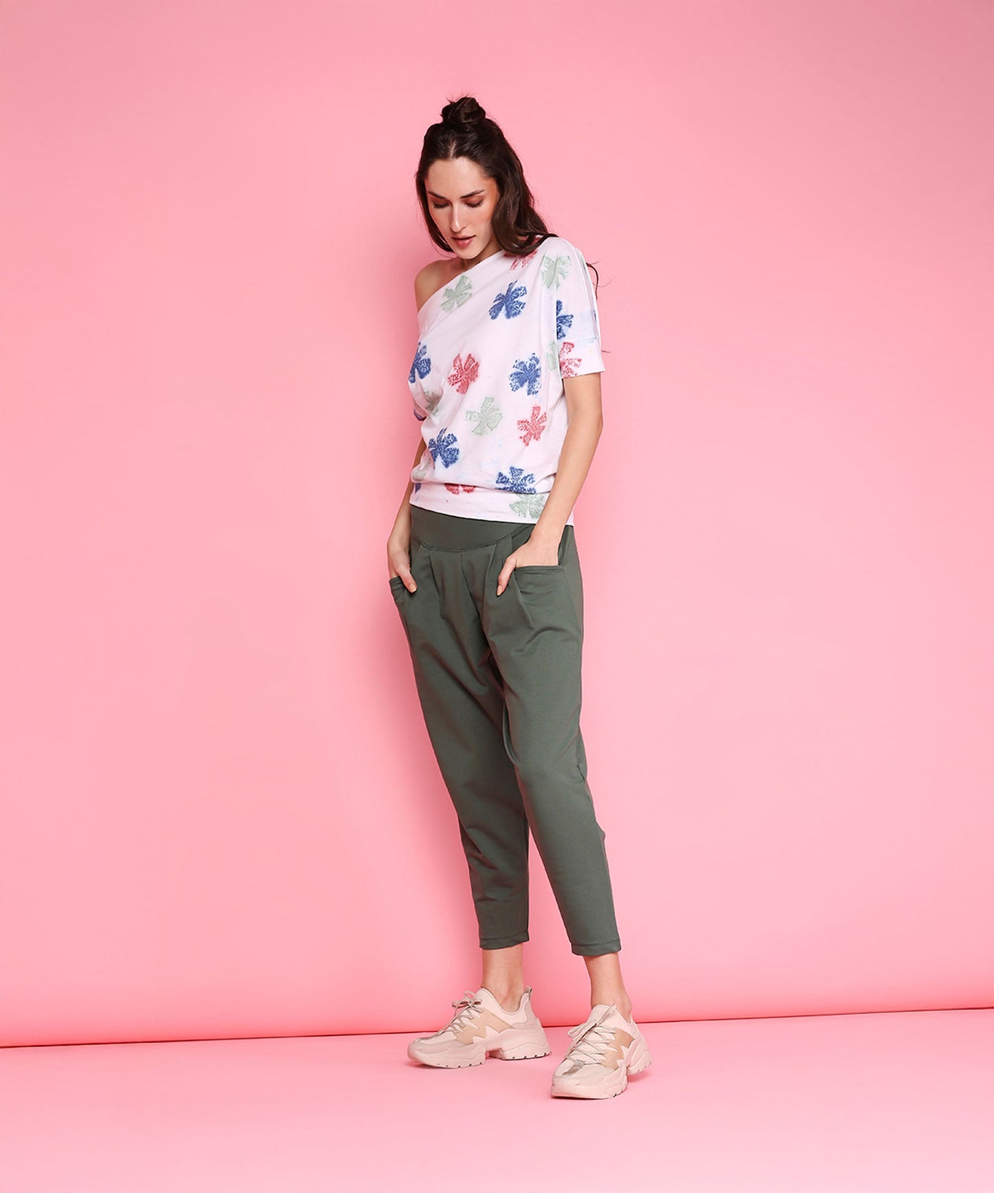 Stylish model wearing comfortable yoga pants with pockets and a floral off-shoulder top