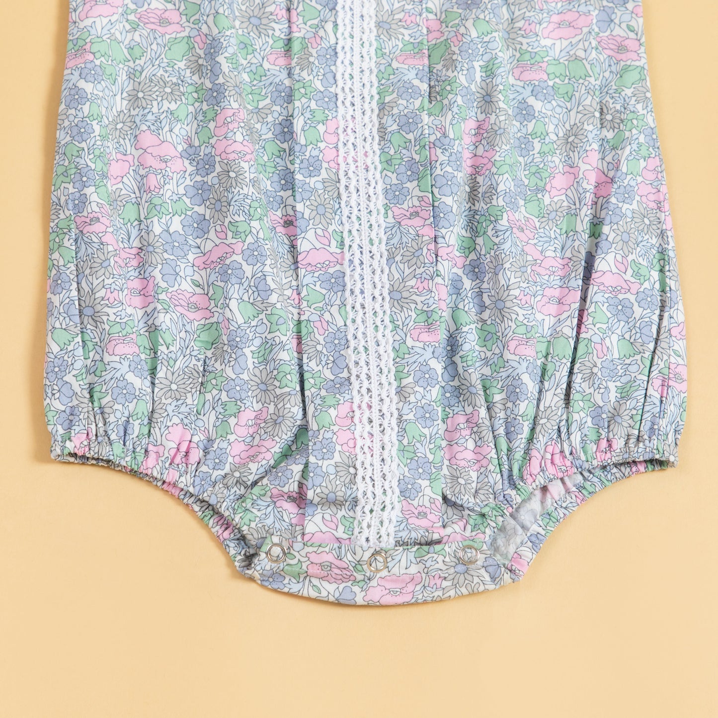 Cute summer romper for babies with floral print and lace details in pastel colors