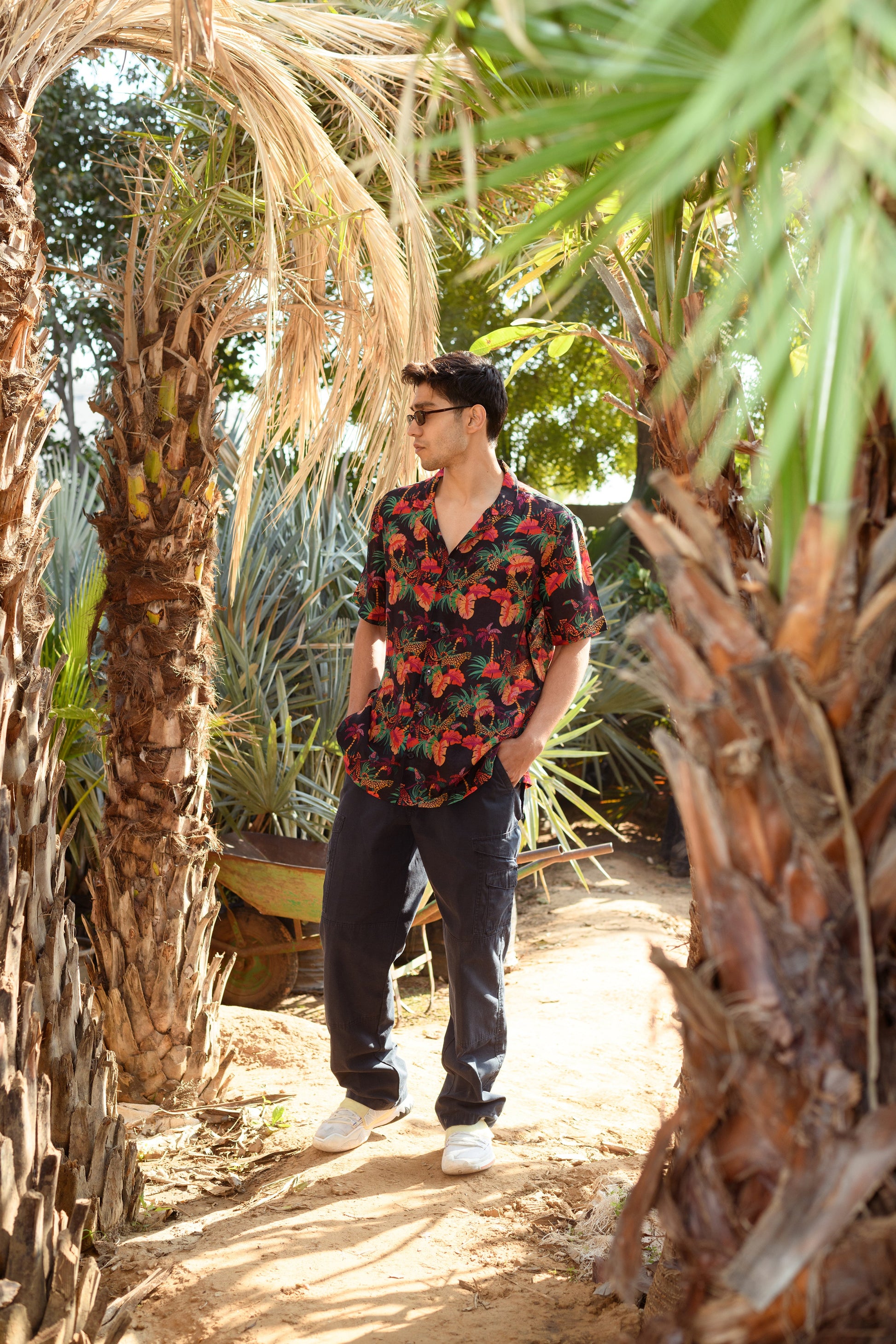Men wearing designer animal print shirt for men, surrounded by tropical palm trees outdoors