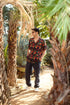 Men wearing designer animal print shirt for men, surrounded by tropical palm trees outdoors