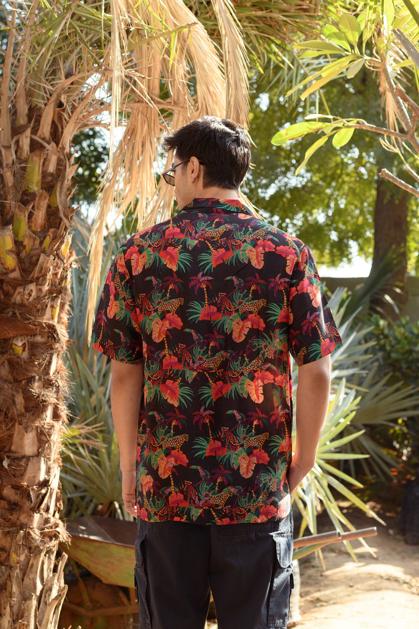 Back view of a designer animal print shirt for men featuring vibrant tropical patterns and colors