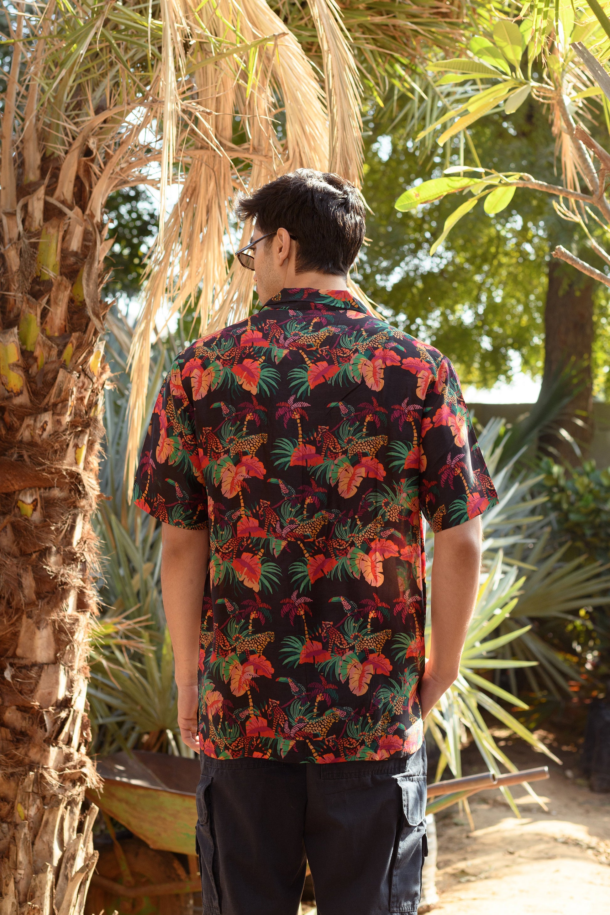 Back view of a designer animal print shirt for men featuring vibrant tropical patterns and colors