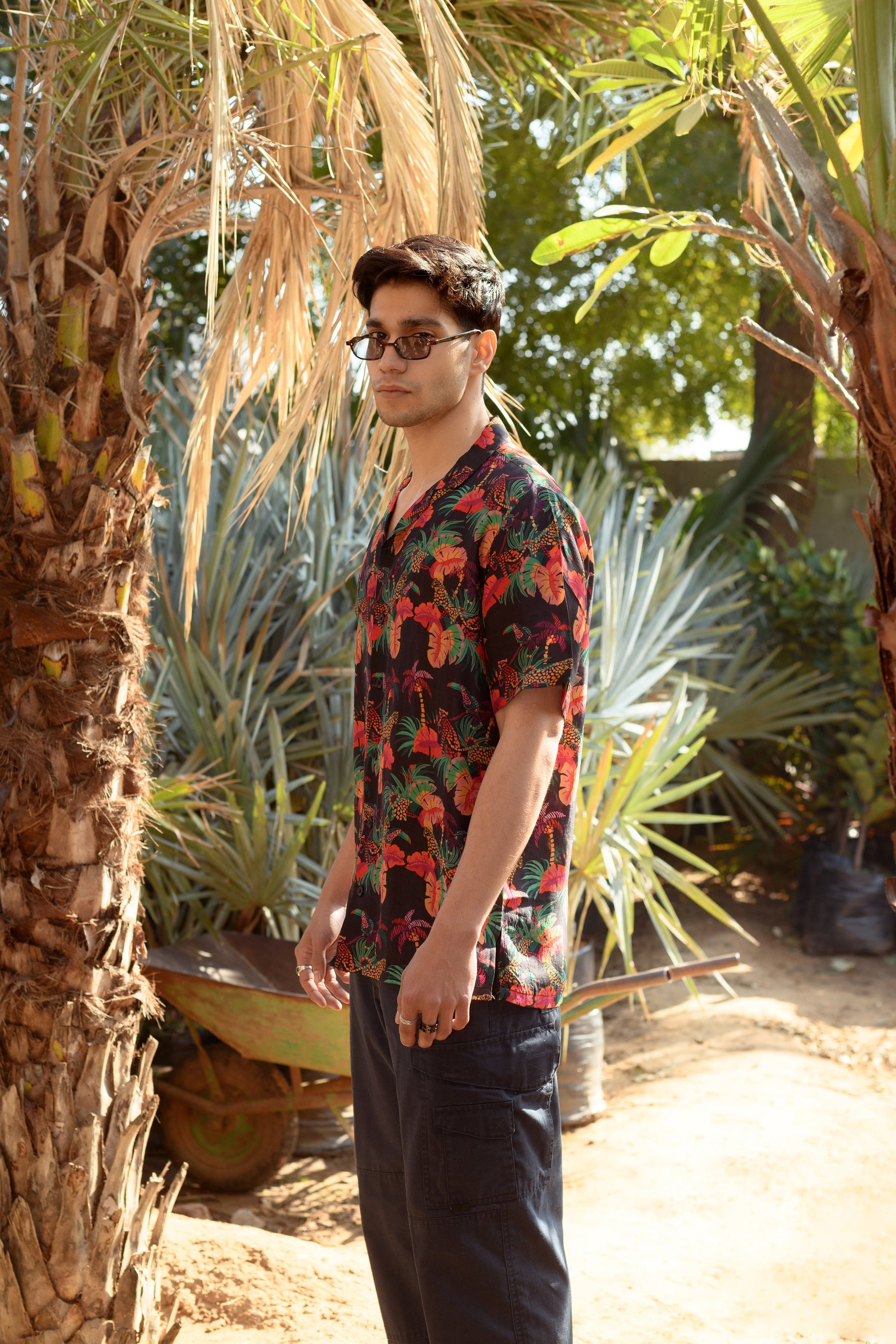 Men's designer animal print shirt for men in vibrant colors set against a tropical background