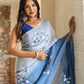 Elegant designer blue saree for women featuring floral patterns, styled with a blue blouse and hanging earrings