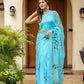 Stylera designer blue saree for women with floral embroidery and elegant drape in a garden setting