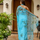 Elegant designer blue saree for women with floral embroidery, showcased in a stylish outdoor setting