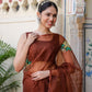Elegant woman wearing a designer brown saree for wedding with intricate embroidery details