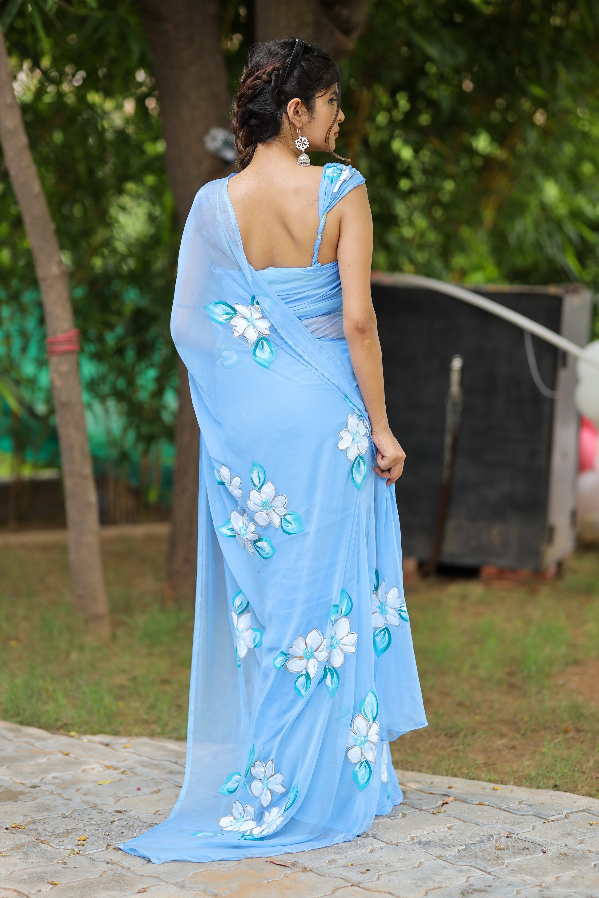 DiraByDimple designer chiffon saree with floral painting in blue, elegantly draped on a model outdoors
