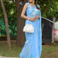 Elegant blue designer chiffon saree with floral painting draped beautifully on a model in a natural setting