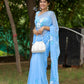 Elegant designer chiffon saree with floral painting in blue, worn by a model with stylish accessories