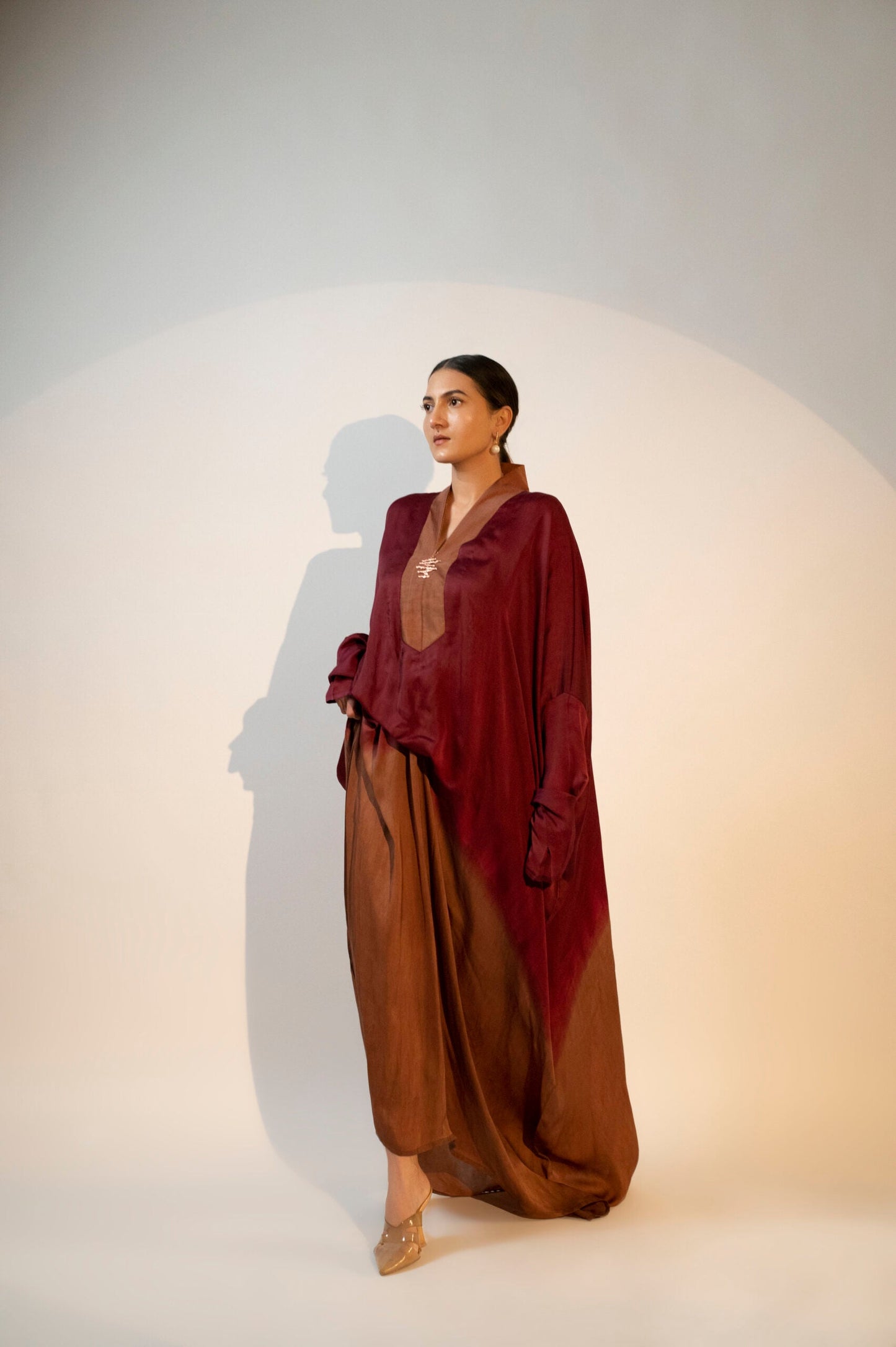Elegant designer evening gown for women featuring a flowing design in rich burgundy and brown tones
