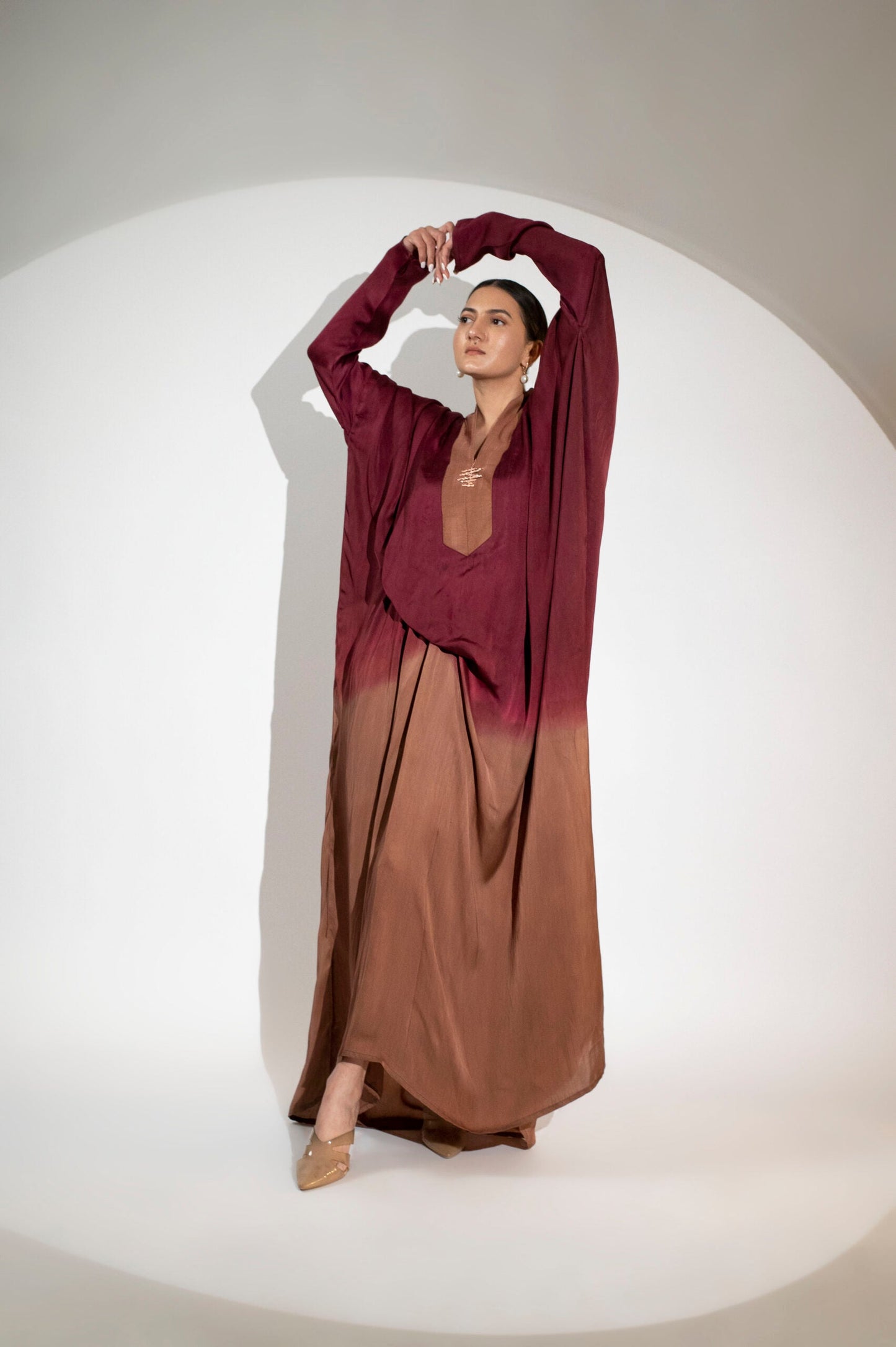 Model wearing a designer evening gown for women with a stylish ombre effect in burgundy and brown