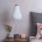 Sozori designer hanging droplet lamp with a unique textured design illuminating a cozy living space