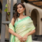 Stylera designer malmal saree with flowers in light green, elegantly draped on a model outdoors