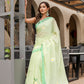 Elegant designer malmal saree with flowers in soft green, paired with matching accessories for a stylish look