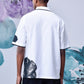 Back view of mens floral polo shirt by Stylera featuring white fabric with black floral accents