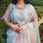 Model wearing a designer party wear organza saree with floral embroidery, styled elegantly for special occasions.