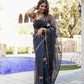 Elegant designer party wear saree for women in black with floral patterns and a stylish drape