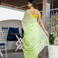 Elegant designer party wear saree in green with floral embroidery, paired with a matching blouse