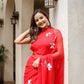 Elegant woman wearing a designer red saree for weddings with floral embroidery, perfect for festive occasions