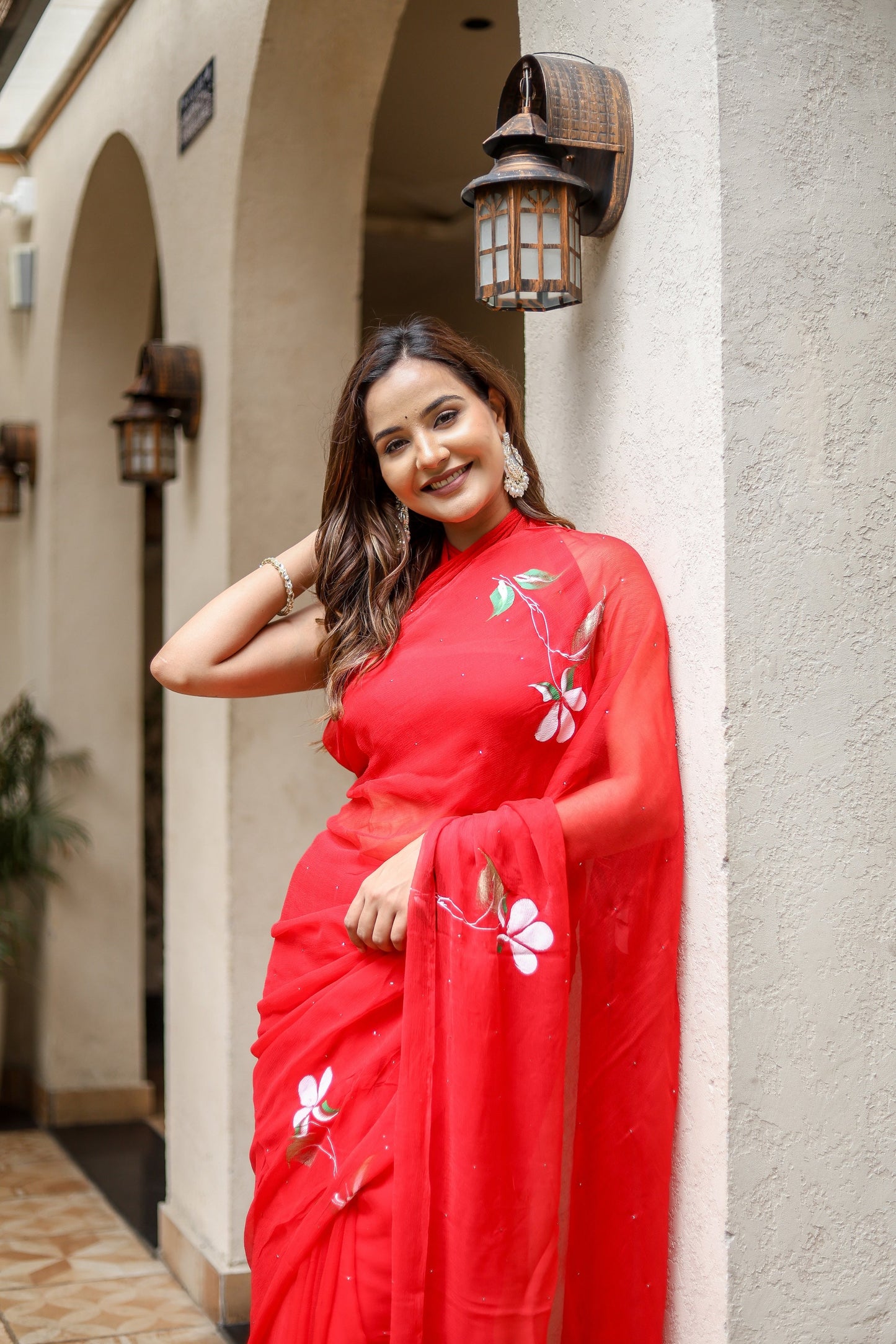 Elegant woman wearing a designer red saree for weddings with floral embroidery, perfect for festive occasions