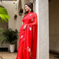 Elegant designer red saree for weddings with floral embroidery draped gracefully outdoors