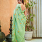 Elegant green designer saree for women featuring floral designs, styled with statement earrings