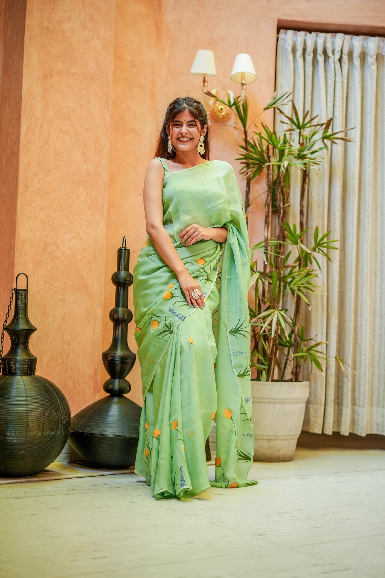 Elegant designer saree for women in light green with floral embroidery and a graceful drape